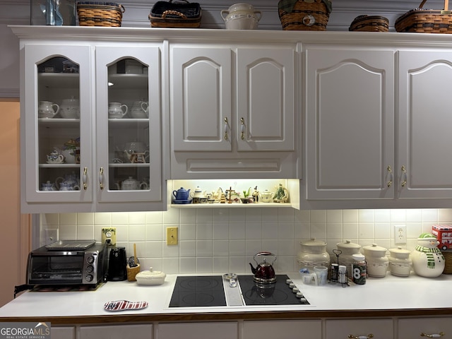 bar with white cabinetry, black electric stovetop, and decorative backsplash