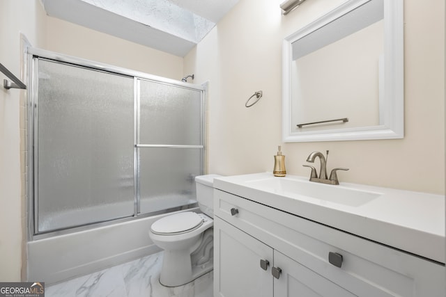 full bathroom with enclosed tub / shower combo, vanity, and toilet