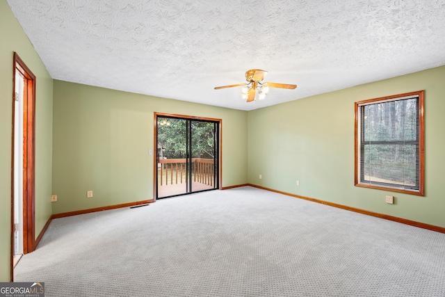 spare room with ceiling fan, light carpet, and a textured ceiling