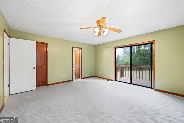 empty room featuring ceiling fan, light colored carpet, and a textured ceiling