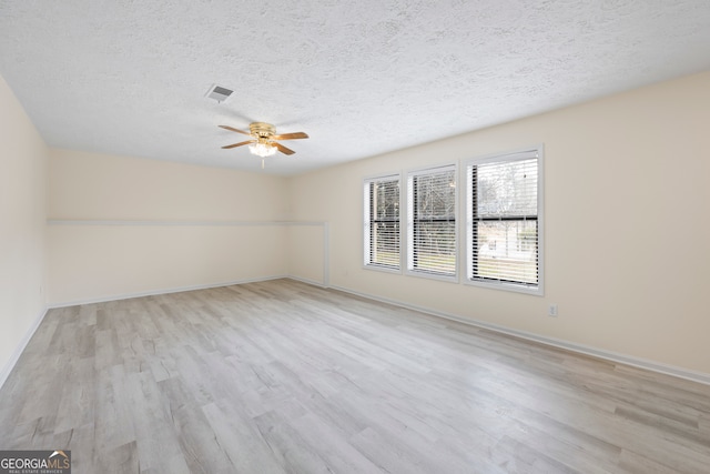 empty room featuring ceiling fan, a textured ceiling, and light hardwood / wood-style flooring