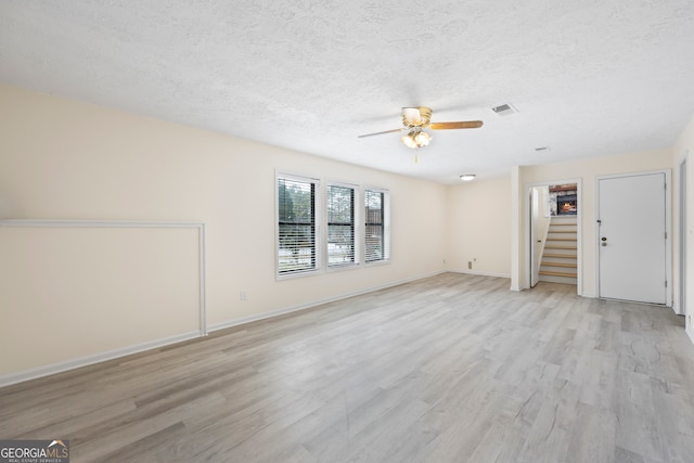 unfurnished living room with ceiling fan, a textured ceiling, and light wood-type flooring