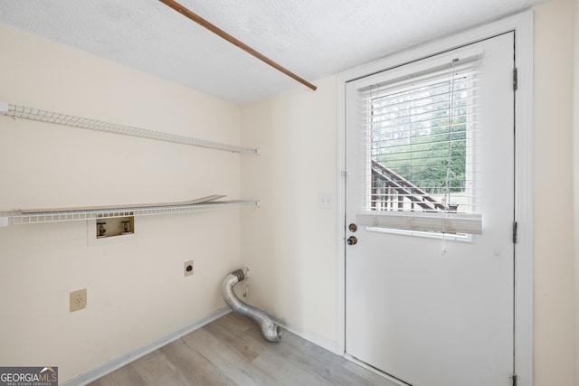 clothes washing area featuring washer hookup, hookup for an electric dryer, a textured ceiling, and light hardwood / wood-style floors