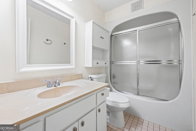 full bathroom with shower / bath combination with glass door, tile patterned flooring, vanity, toilet, and a textured ceiling