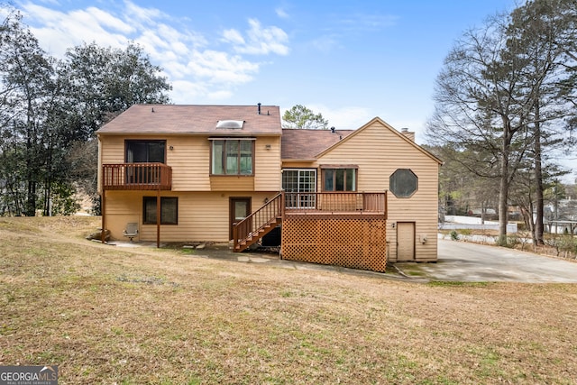 rear view of house with a yard and a deck