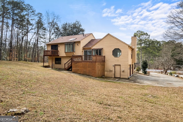 rear view of house with a deck and a lawn