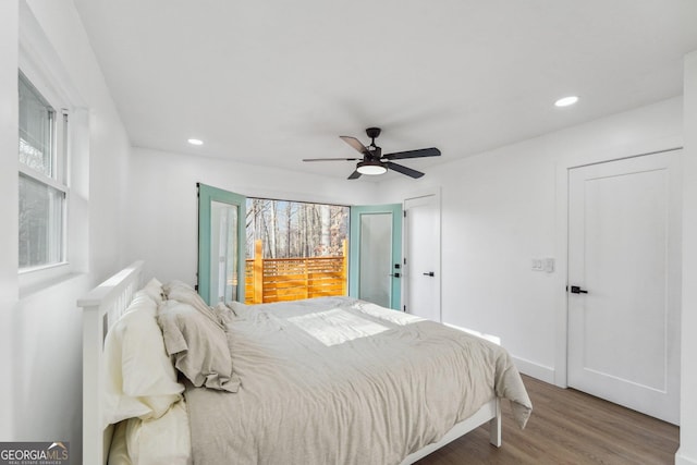 bedroom featuring ceiling fan, wood-type flooring, and multiple windows