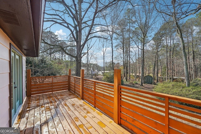 wooden deck featuring a storage unit