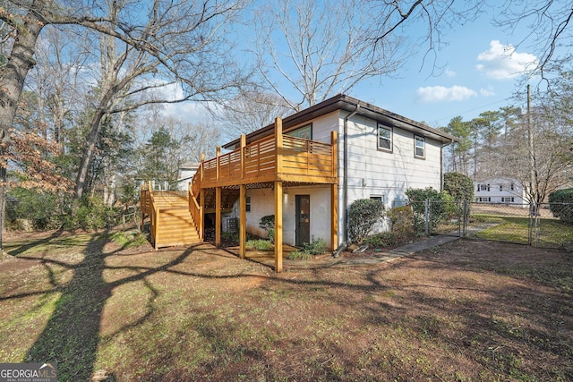 rear view of property featuring a deck and a lawn