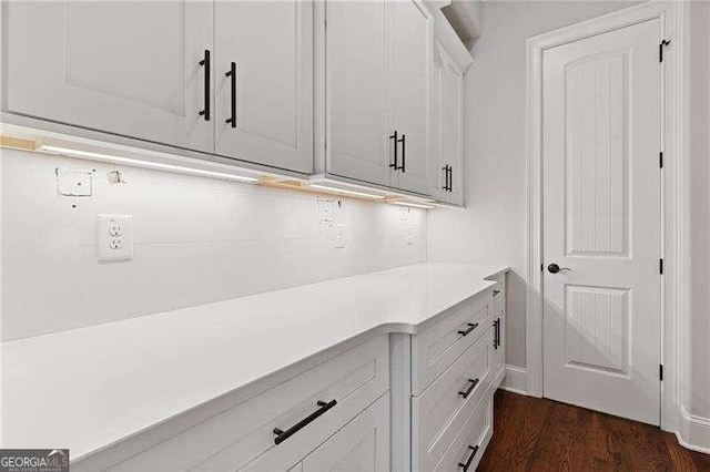 bar featuring dark hardwood / wood-style floors and white cabinets