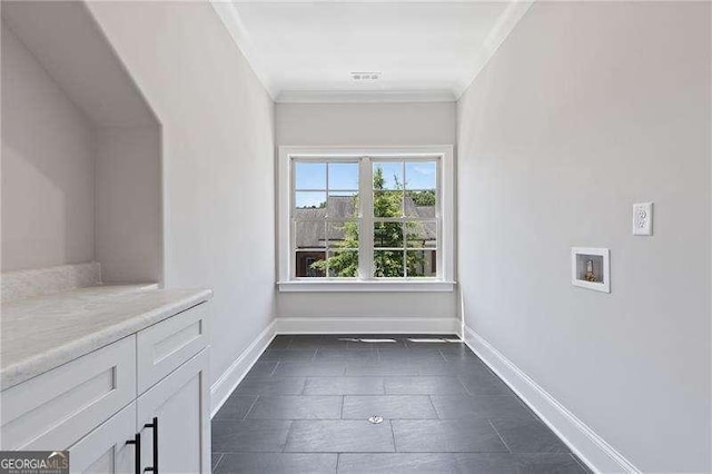 interior space featuring crown molding, hookup for a washing machine, and cabinets