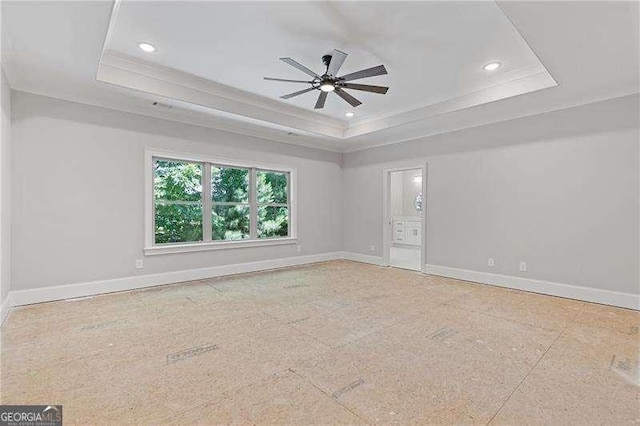 empty room featuring crown molding, a raised ceiling, and ceiling fan