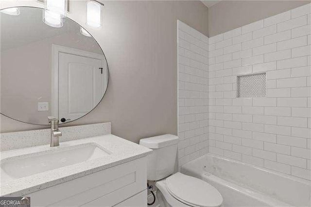 full bathroom with vanity, tiled shower / bath combo, and toilet