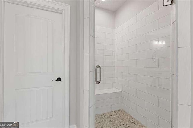 bathroom featuring a shower with door