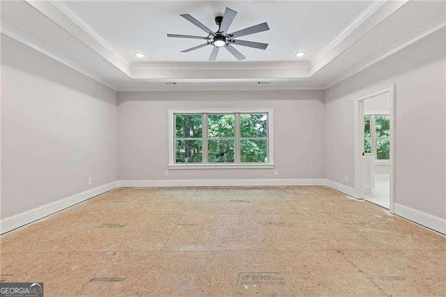 spare room with crown molding, plenty of natural light, and a raised ceiling