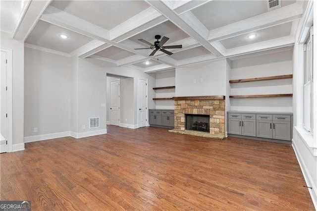 unfurnished living room featuring dark wood-type flooring, ceiling fan, coffered ceiling, and a fireplace