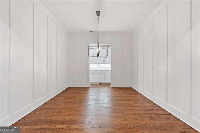 unfurnished dining area with dark wood-type flooring