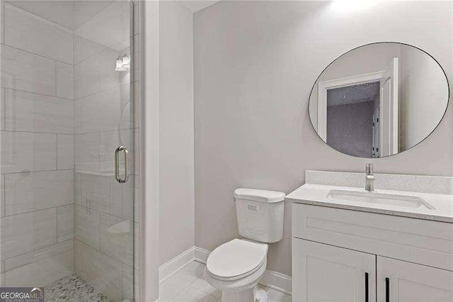 bathroom with vanity, a shower with shower door, and toilet