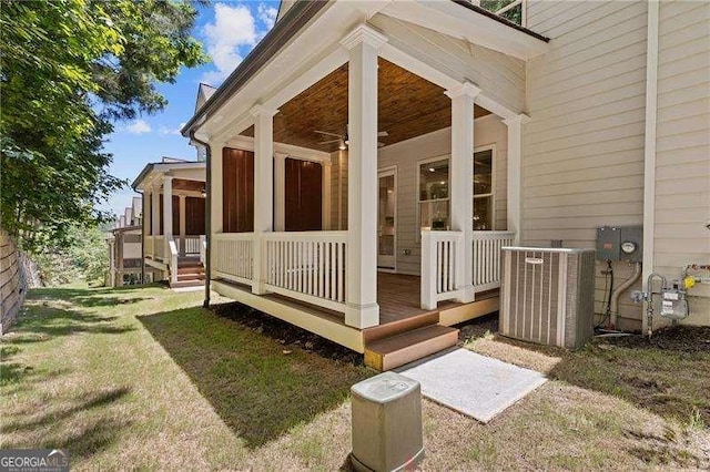 entrance to property featuring ceiling fan, a lawn, and central air condition unit