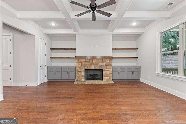 unfurnished living room featuring beamed ceiling, coffered ceiling, a fireplace, and dark hardwood / wood-style flooring