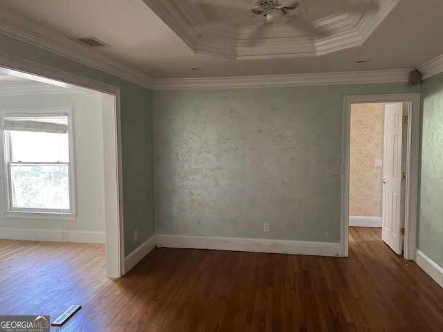 unfurnished room featuring ornamental molding, dark hardwood / wood-style floors, and a tray ceiling