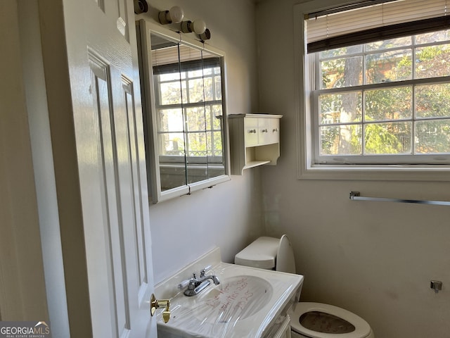 bathroom featuring a healthy amount of sunlight, toilet, and sink