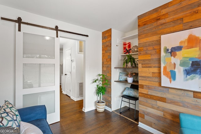 living room featuring a barn door and dark hardwood / wood-style floors