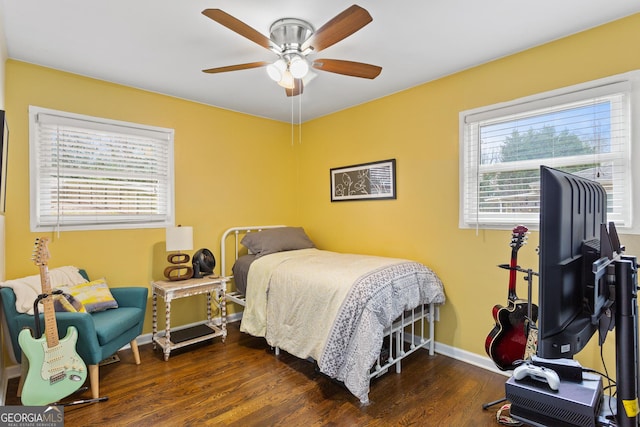 bedroom with dark hardwood / wood-style floors and ceiling fan