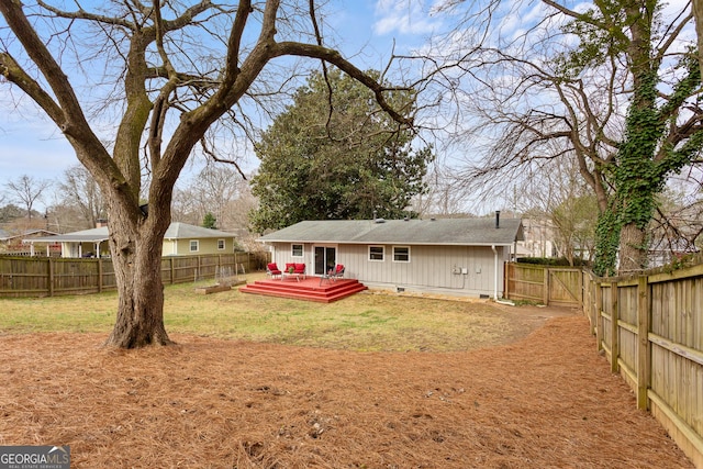 rear view of house with a wooden deck and a lawn