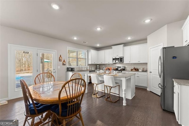 dining space with sink and dark wood-type flooring