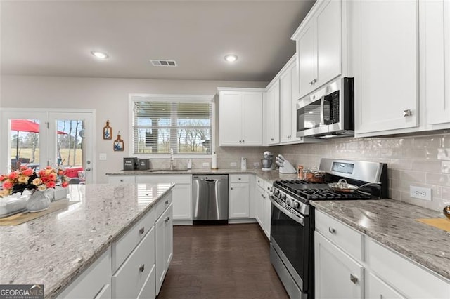 kitchen with stainless steel appliances, white cabinetry, and sink