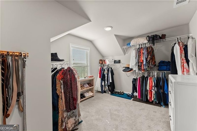 spacious closet with washer / dryer, lofted ceiling, and light carpet