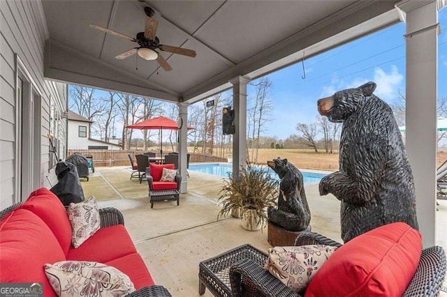 view of patio / terrace with a fenced in pool, outdoor lounge area, and ceiling fan