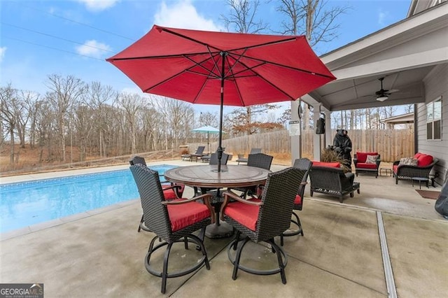 view of patio / terrace with a fenced in pool, an outdoor hangout area, and ceiling fan