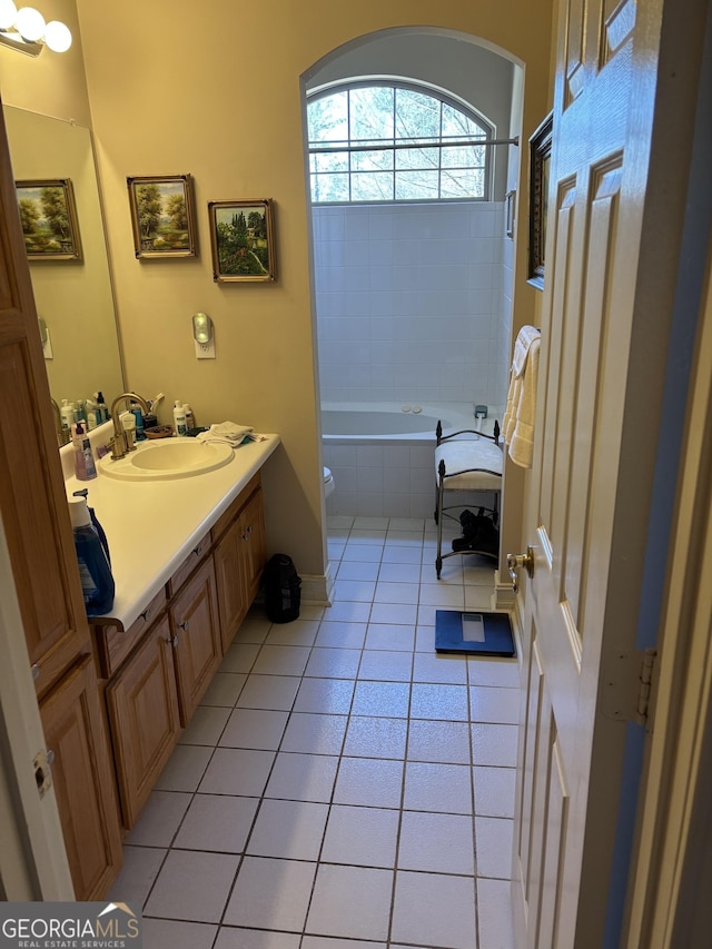 bathroom featuring toilet, vanity, tiled tub, tiled shower, and tile patterned floors