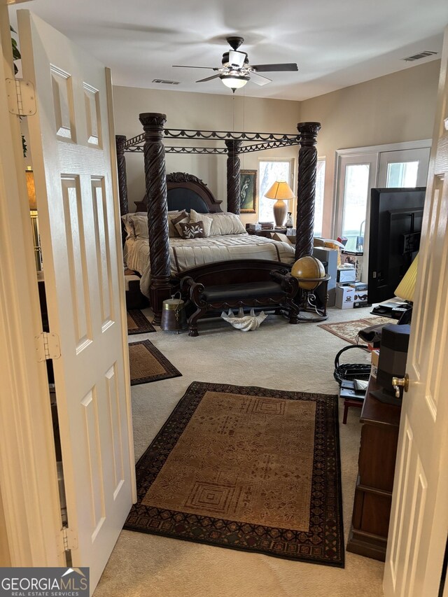 carpeted bedroom featuring ceiling fan and visible vents