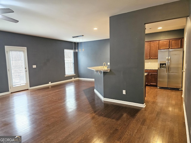 spare room featuring dark hardwood / wood-style flooring, sink, a wealth of natural light, and ceiling fan