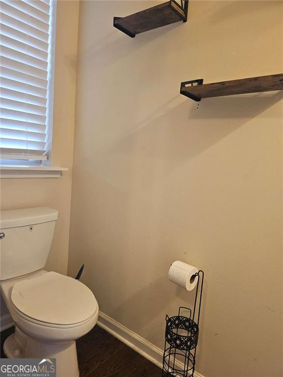 bathroom with hardwood / wood-style flooring and toilet