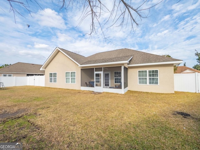 rear view of property with a yard and a sunroom