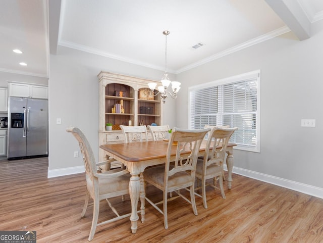 dining space featuring ornamental molding, a notable chandelier, and light hardwood / wood-style floors