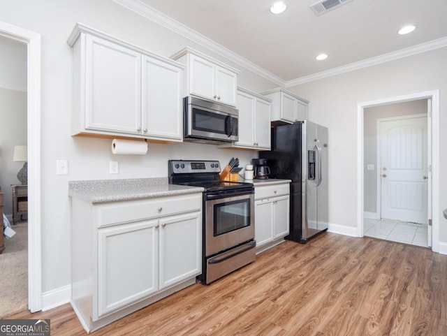 kitchen featuring white cabinetry, appliances with stainless steel finishes, light wood-type flooring, and crown molding