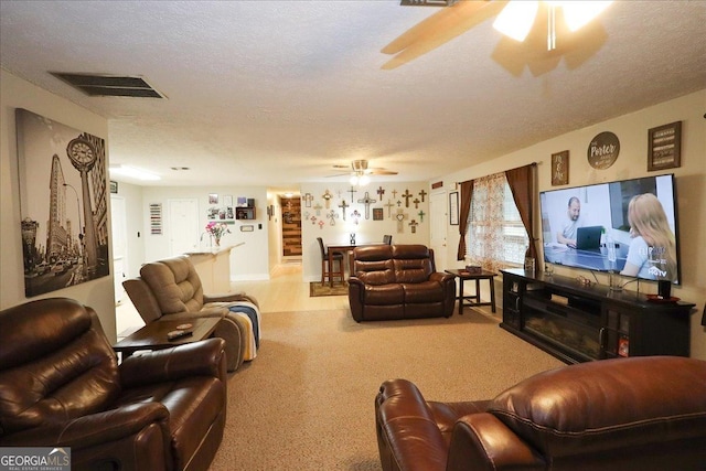 carpeted living room featuring a textured ceiling and ceiling fan