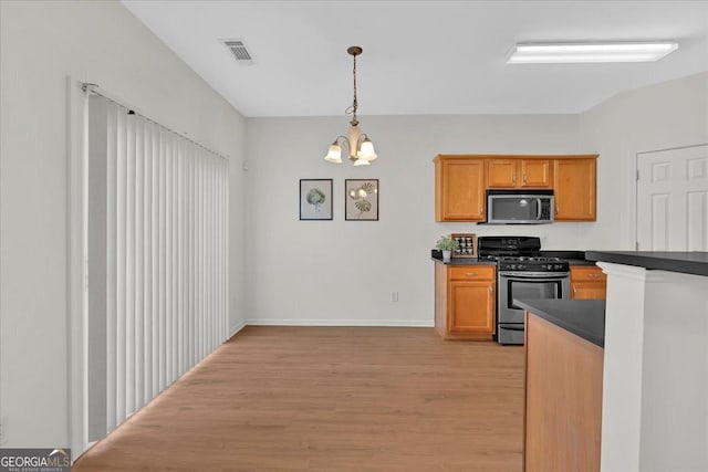 kitchen with stainless steel appliances, an inviting chandelier, light hardwood / wood-style floors, and decorative light fixtures