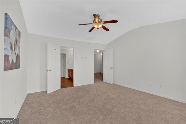 unfurnished bedroom with lofted ceiling, ensuite bath, ceiling fan, and carpet flooring