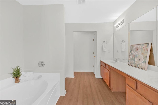 bathroom with vanity, wood-type flooring, and a bathing tub