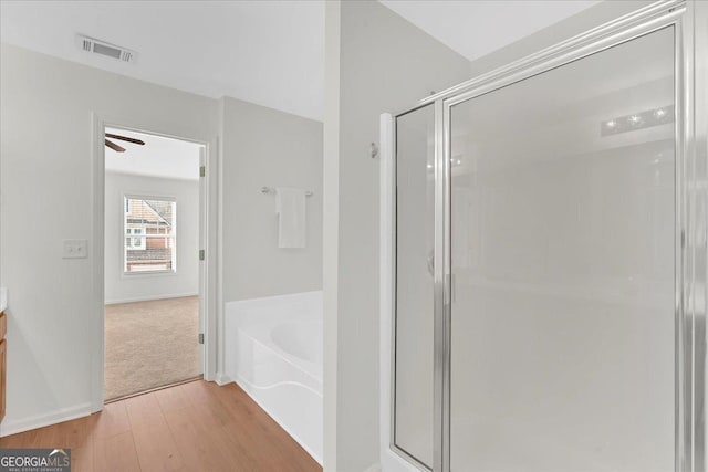 bathroom with hardwood / wood-style flooring, vanity, and separate shower and tub