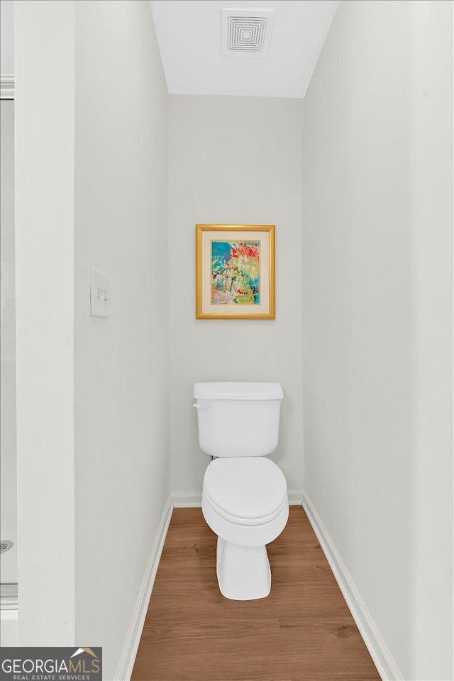 bathroom with wood-type flooring and toilet