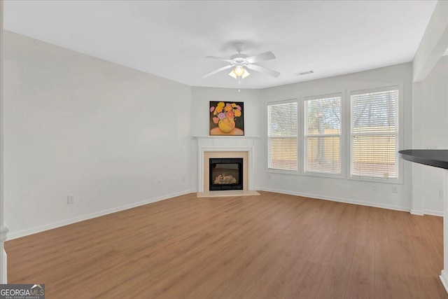 unfurnished living room featuring ceiling fan and light hardwood / wood-style floors