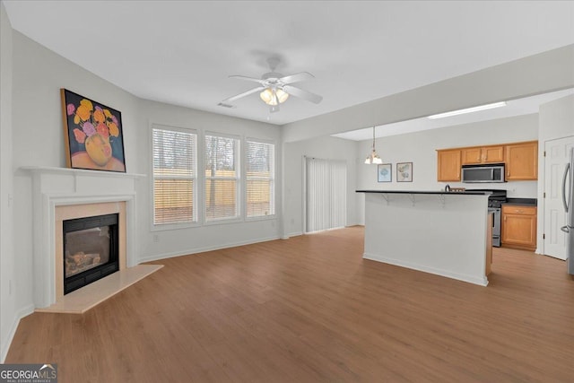 unfurnished living room featuring light hardwood / wood-style flooring and ceiling fan