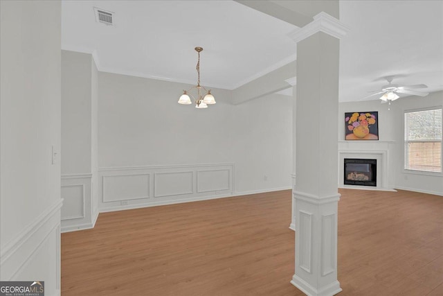 unfurnished living room with crown molding, light hardwood / wood-style floors, and ornate columns